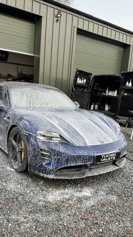 Porsche Taycan under snow foam during a mobile valet